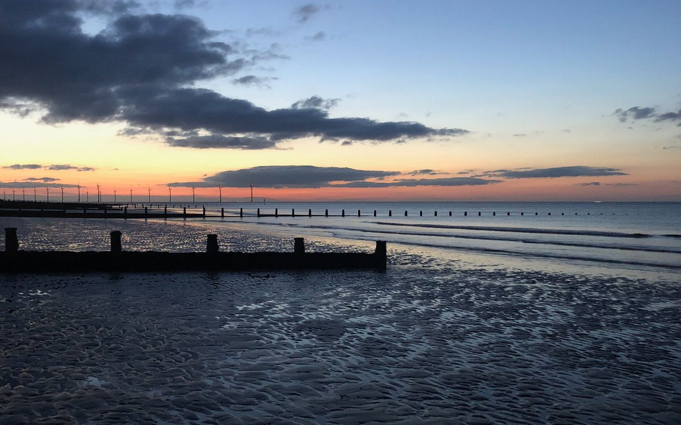 Sunset over Redcar beach on the Teesside coast, with the offshore wind farm on the horizon
